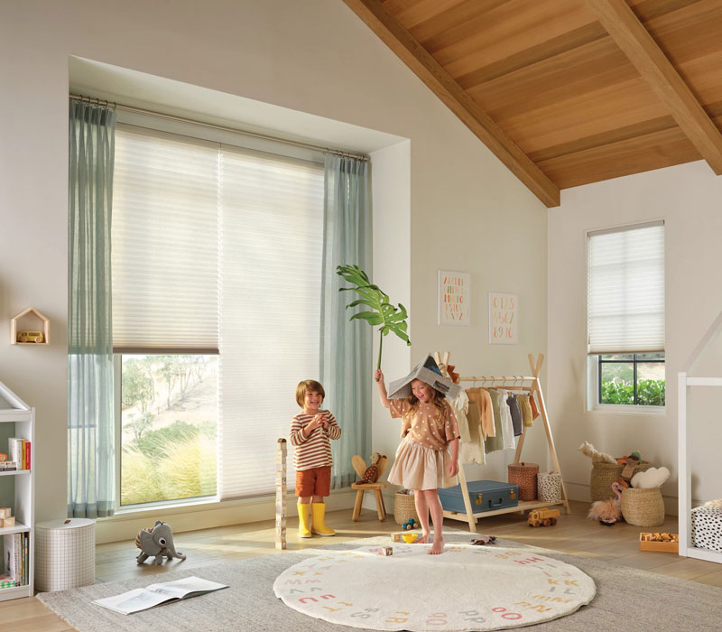 two kids playing in nursery with cellular shade window coverings